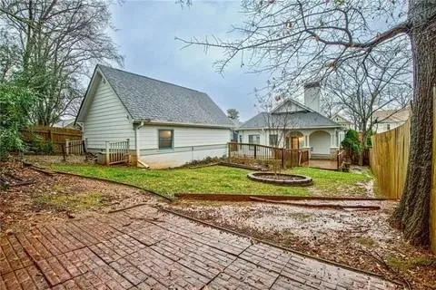 a view of a house with a yard and large tree