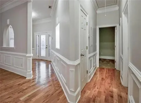 a view of a hallway with wooden floor and stairs