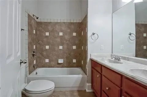 a bathroom with a sink a toilet a mirror a bathtub and shower