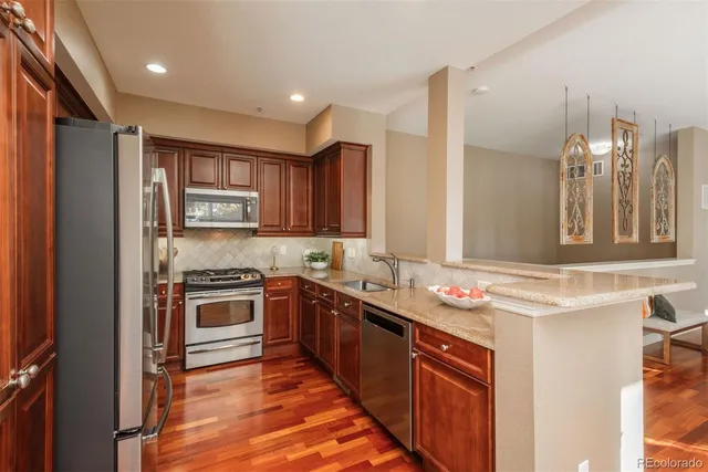 a kitchen with stainless steel appliances granite countertop stove a sink and a refrigerator