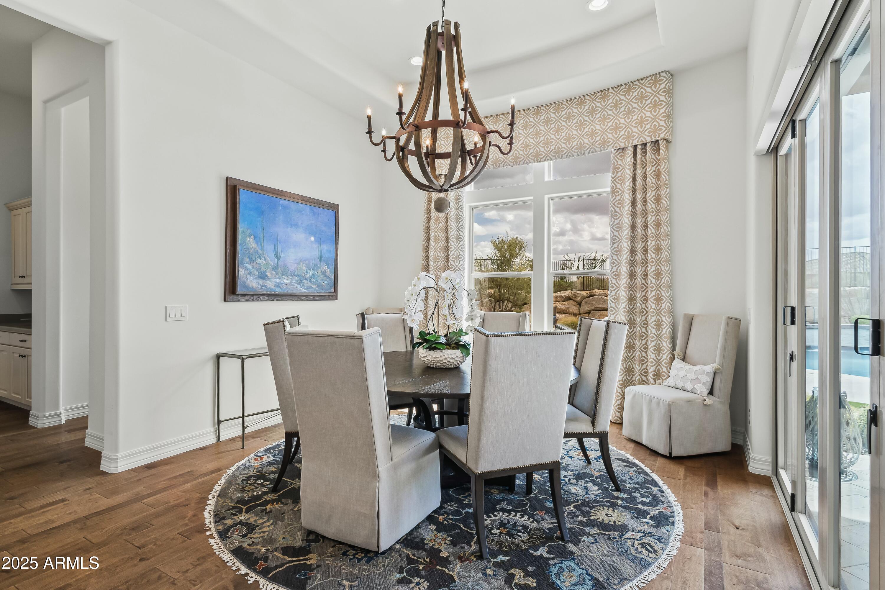 8769 East Granite Pass Road Scottsdale, AZ 85266 - Photo 6 of 23 a dining room with furniture a chandelier and wooden floor