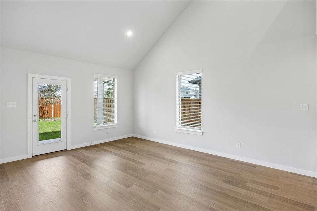 15229 Supreme Street Aledo, TX 76008 - Photo 12 of 36 an empty room with wooden floor and windows