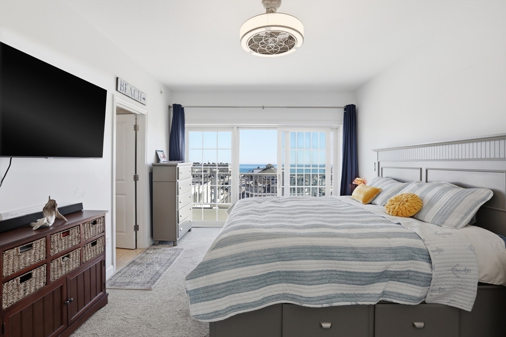 233 Beach Road, Unit A10 Salisbury, MA 01952 - Photo 19 of 39 a bedroom with a bed and a flat screen tv