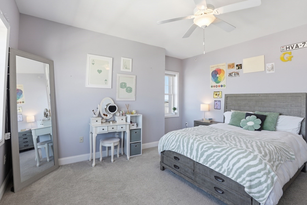 233 Beach Road, Unit A10 Salisbury, MA 01952 - Photo 27 of 39 a bedroom with a bed and a chandelier