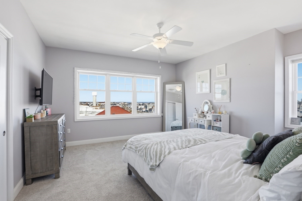 233 Beach Road, Unit A10 Salisbury, MA 01952 - Photo 28 of 39 a bedroom with a large bed and a flat tv screen on dresser