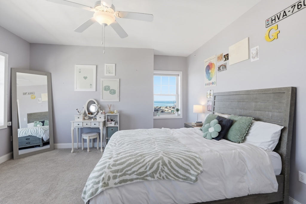 233 Beach Road, Unit A10 Salisbury, MA 01952 - Photo 29 of 39 a bedroom with a bed and a chandelier