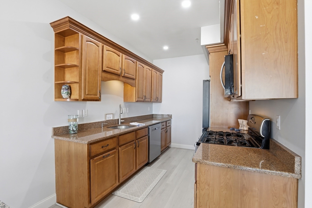 233 Beach Road, Unit A10 Salisbury, MA 01952 - Photo 6 of 39 a kitchen with stainless steel appliances granite countertop a sink stove and cabinets