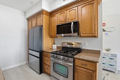 a kitchen with stainless steel appliances granite countertop a sink stove and cabinets