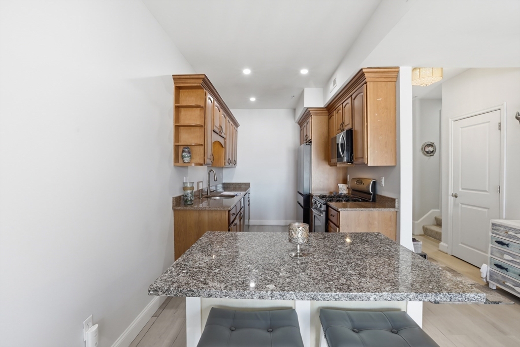 233 Beach Road, Unit A10 Salisbury, MA 01952 - Photo 8 of 39 a kitchen with stainless steel appliances granite countertop a sink stove and refrigerator