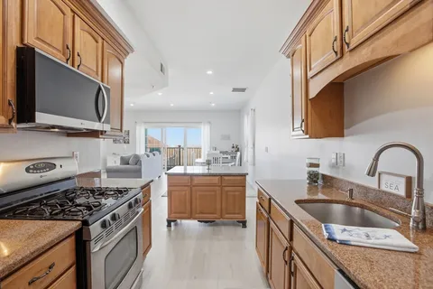 a kitchen with stainless steel appliances granite countertop a sink stove and refrigerator