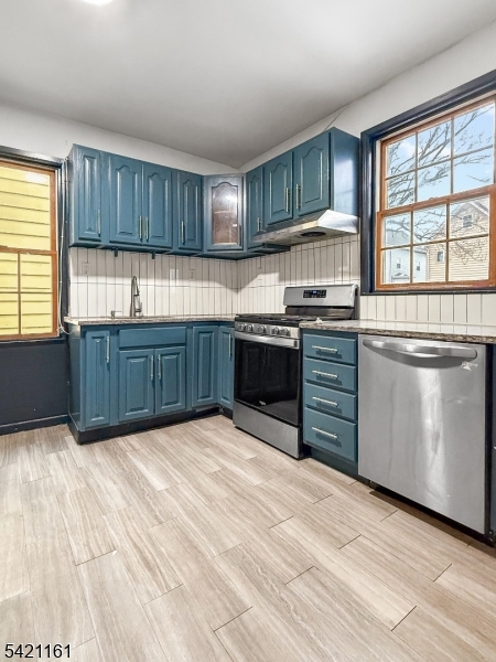 66 Washington Place East Rutherford, NJ 07073 - Photo 20 of 35 a kitchen with stainless steel appliances granite countertop a stove top oven a sink dishwasher a dining table and chairs with wooden floor