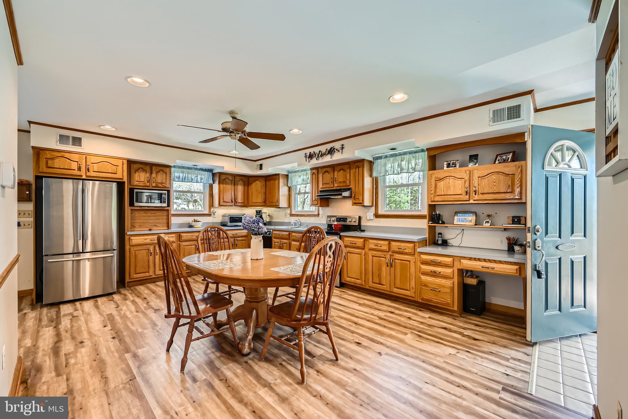 1722 Anne Avenue Baltimore, MD 21221 - Photo 9 of 28 a kitchen with stainless steel appliances granite countertop a refrigerator a stove top oven and a dining table with wooden floor