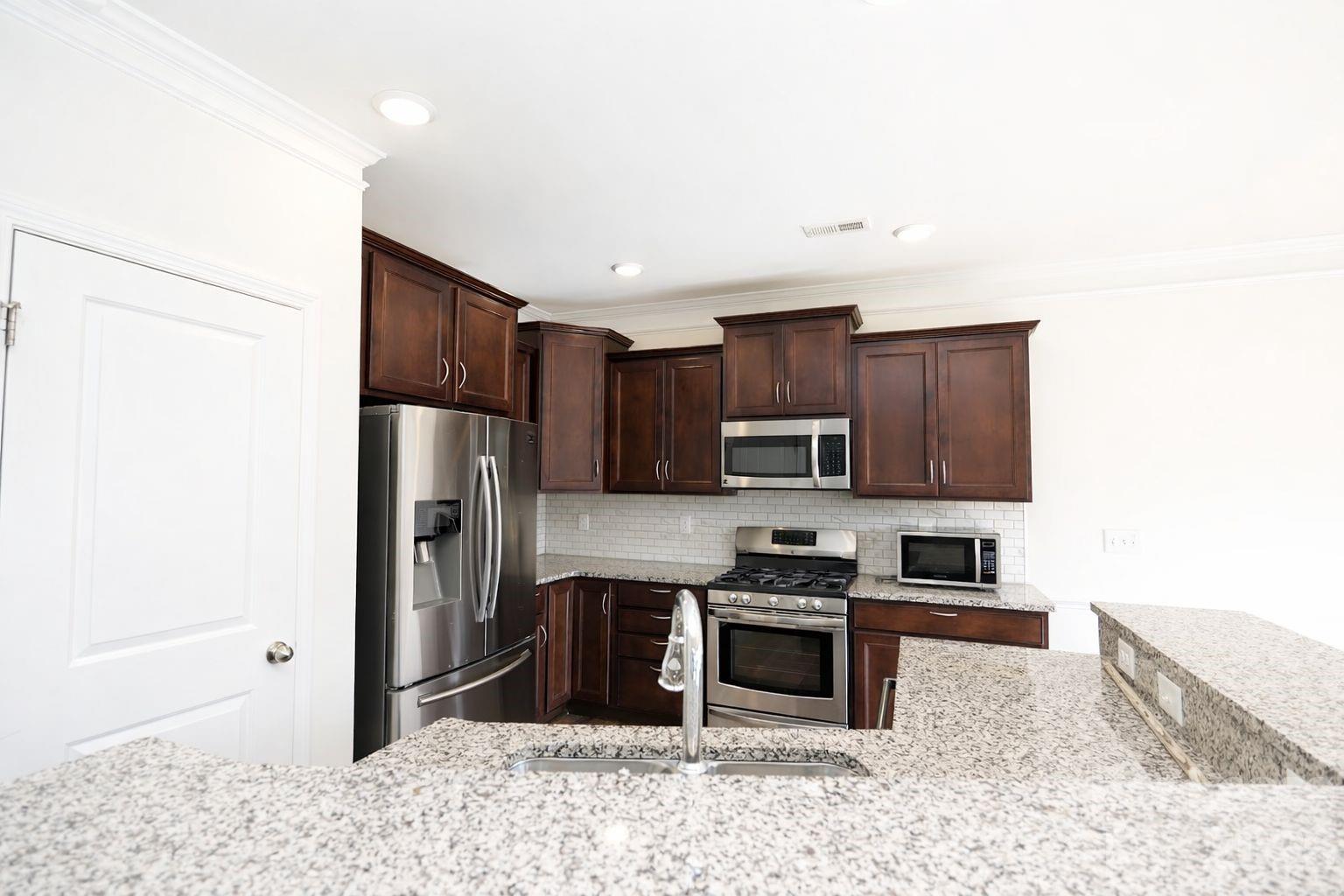 3220 Berry Creek Road Charlotte, NC 28214 - Photo 14 of 41 a kitchen with stainless steel appliances granite countertop a refrigerator stove and sink