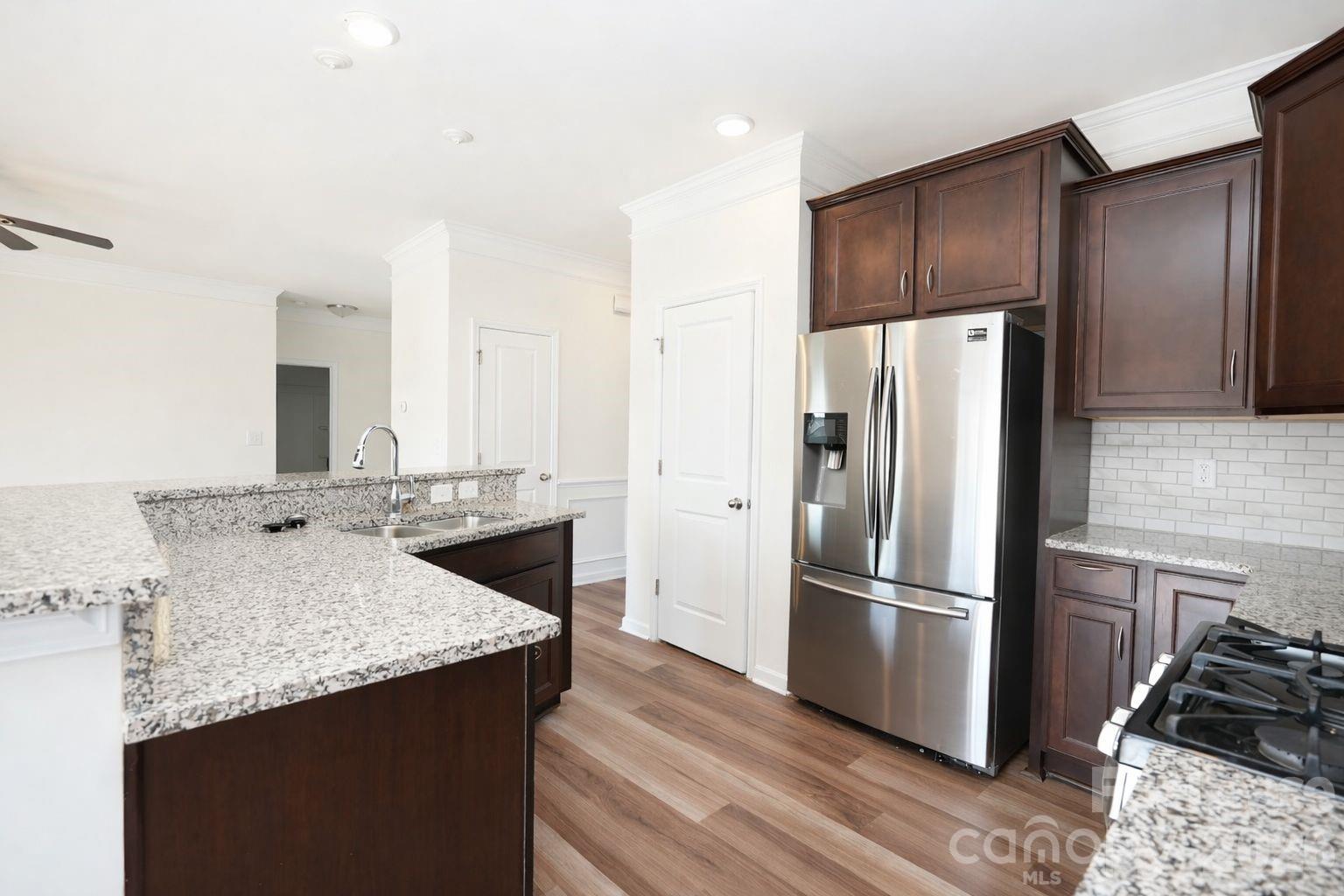 3220 Berry Creek Road Charlotte, NC 28214 - Photo 16 of 41 a kitchen with granite countertop a refrigerator and a stove top oven