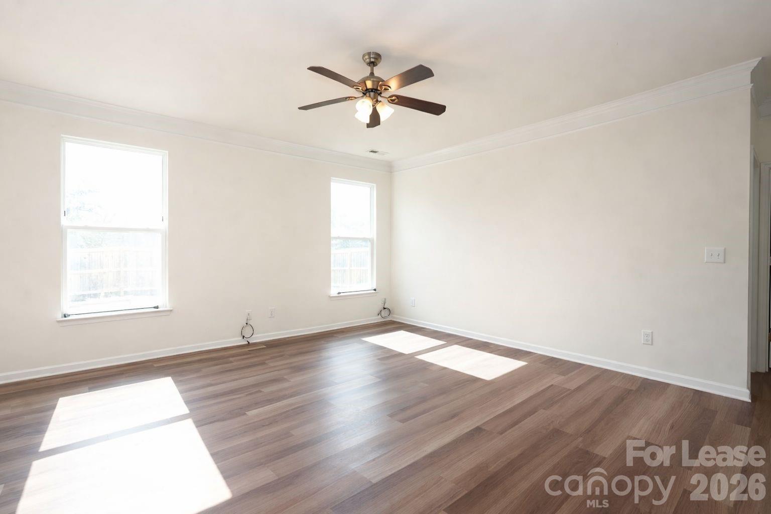 3220 Berry Creek Road Charlotte, NC 28214 - Photo 7 of 41 an empty room with wooden floor fan and windows