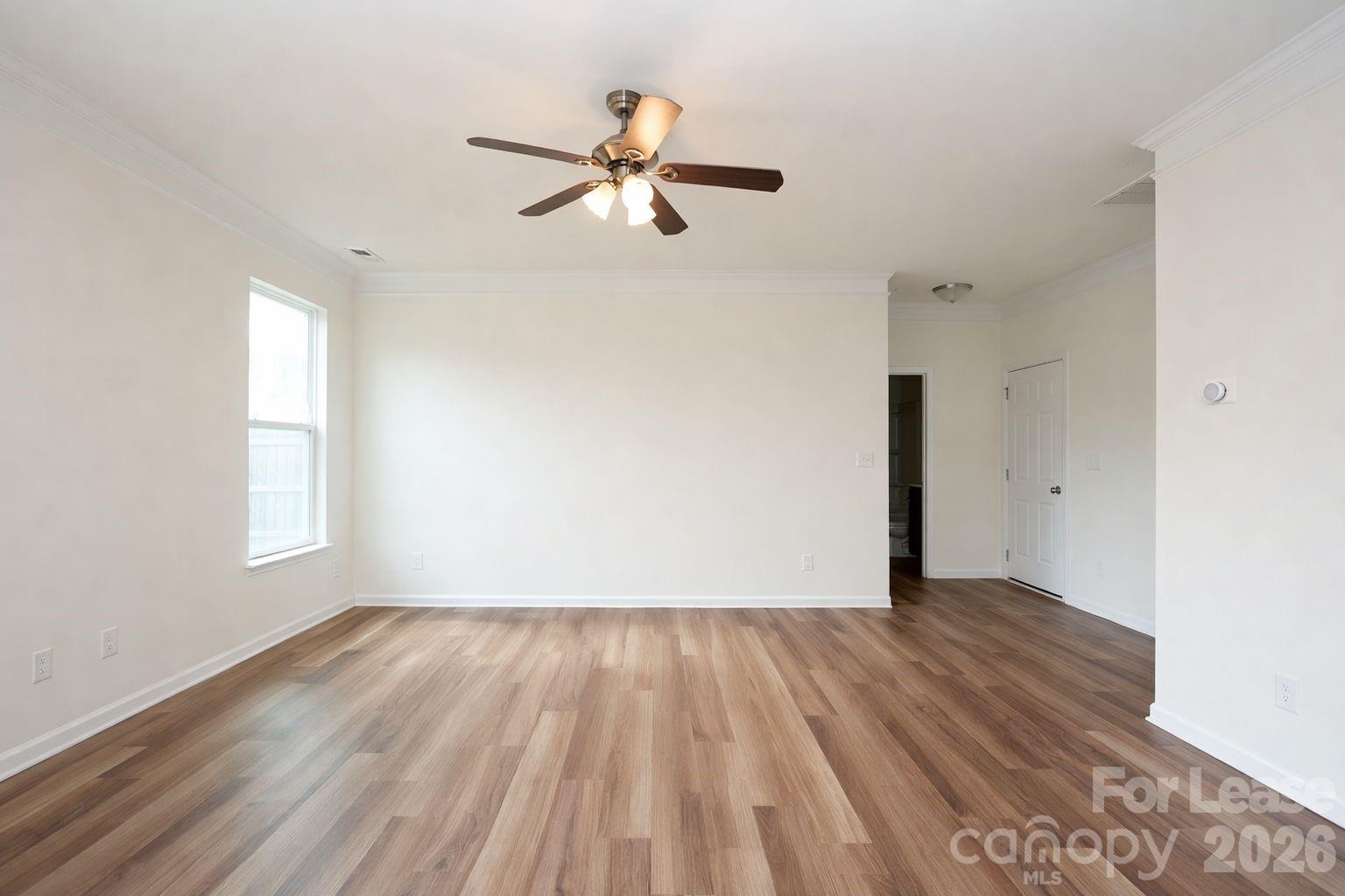 3220 Berry Creek Road Charlotte, NC 28214 - Photo 8 of 41 an empty room with wooden floor fan and windows