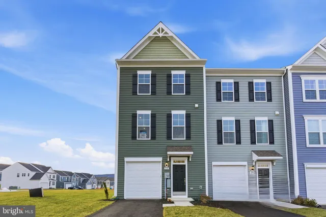 a front view of a house with a garden and plants