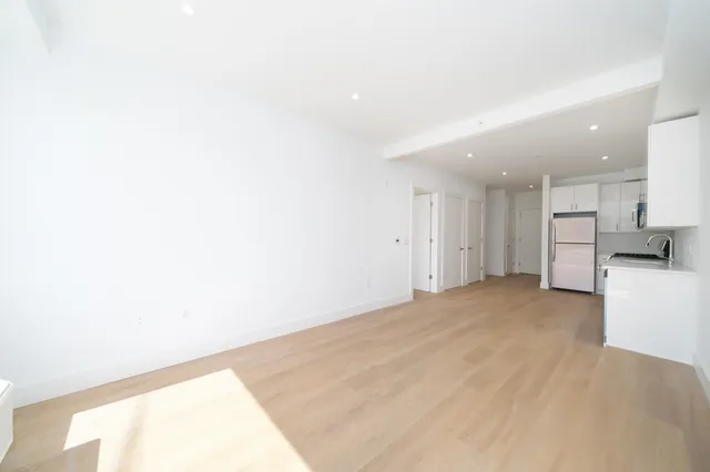 a view of empty room with kitchen