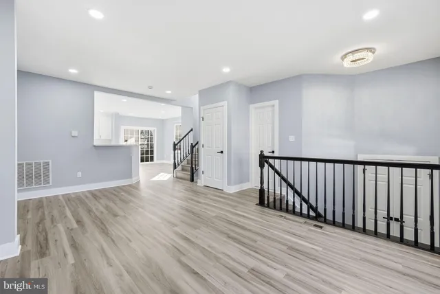 a view of a hallway with wooden floor and windows