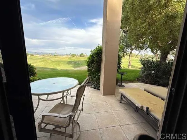 a view of a chairs and table in patio with a yard