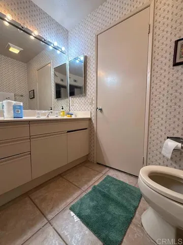 a bathroom with a double vanity sink mirror and toilet