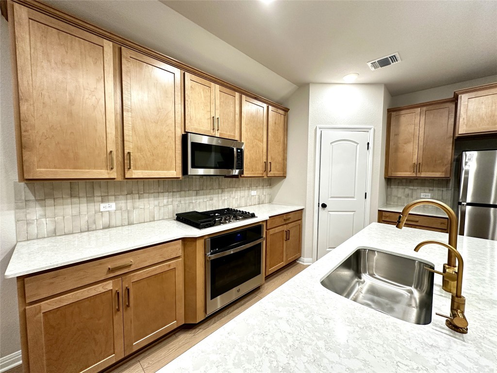 141 Rita Blanca Bend Bastrop, TX 78602 - Photo 1 of 23 a kitchen with stainless steel appliances granite countertop a sink stove refrigerator and cabinets