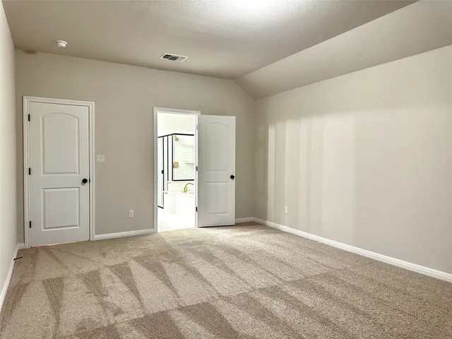 a view of an empty room with window and closet area