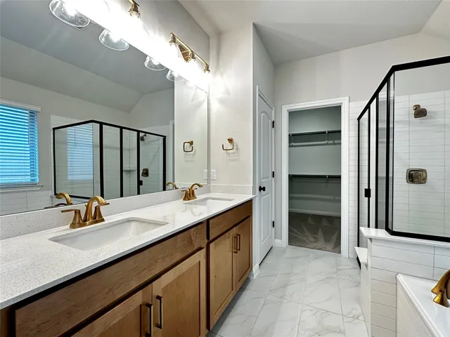 a bathroom with a double vanity sink a mirror and a shower