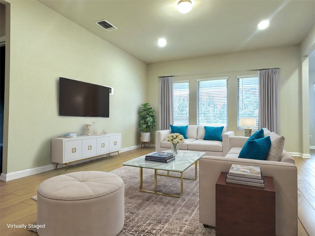 141 Rita Blanca Bend Bastrop, TX 78602 - Photo 5 of 23 a living room with furniture a flat screen tv and a floor to ceiling window
