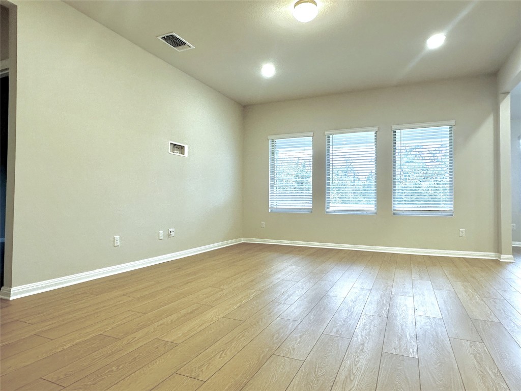 141 Rita Blanca Bend Bastrop, TX 78602 - Photo 6 of 23 an empty room with wooden floor and windows