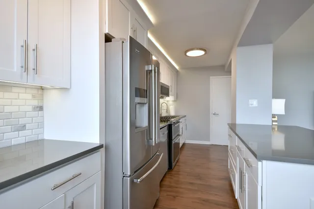 a kitchen with granite countertop a refrigerator and a sink
