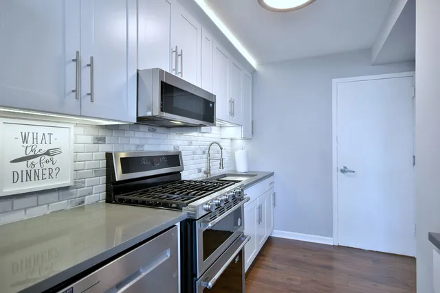 a kitchen with stainless steel appliances a stove a microwave and sink