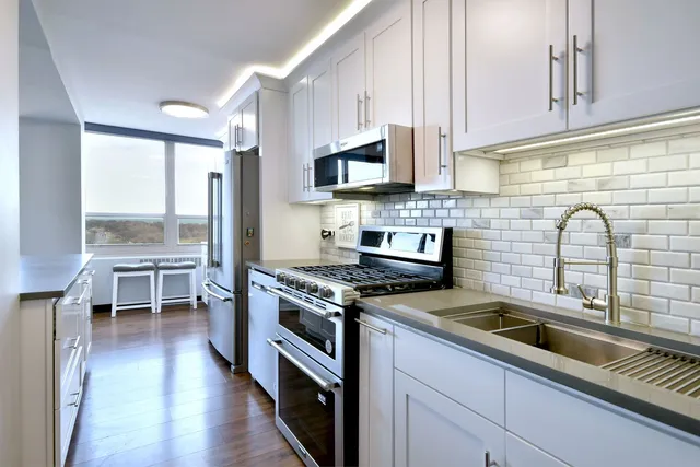 a kitchen with stainless steel appliances a stove sink and cabinets