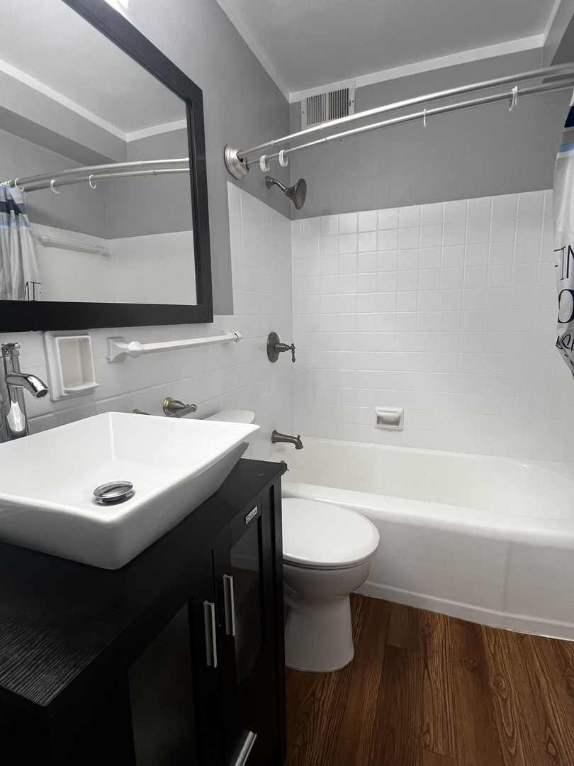3950 North Lake Shore Drive, Unit 1202 Chicago, IL 60613 - Photo 22 of 32 a bathroom with a sink mirror toilet and bathtub