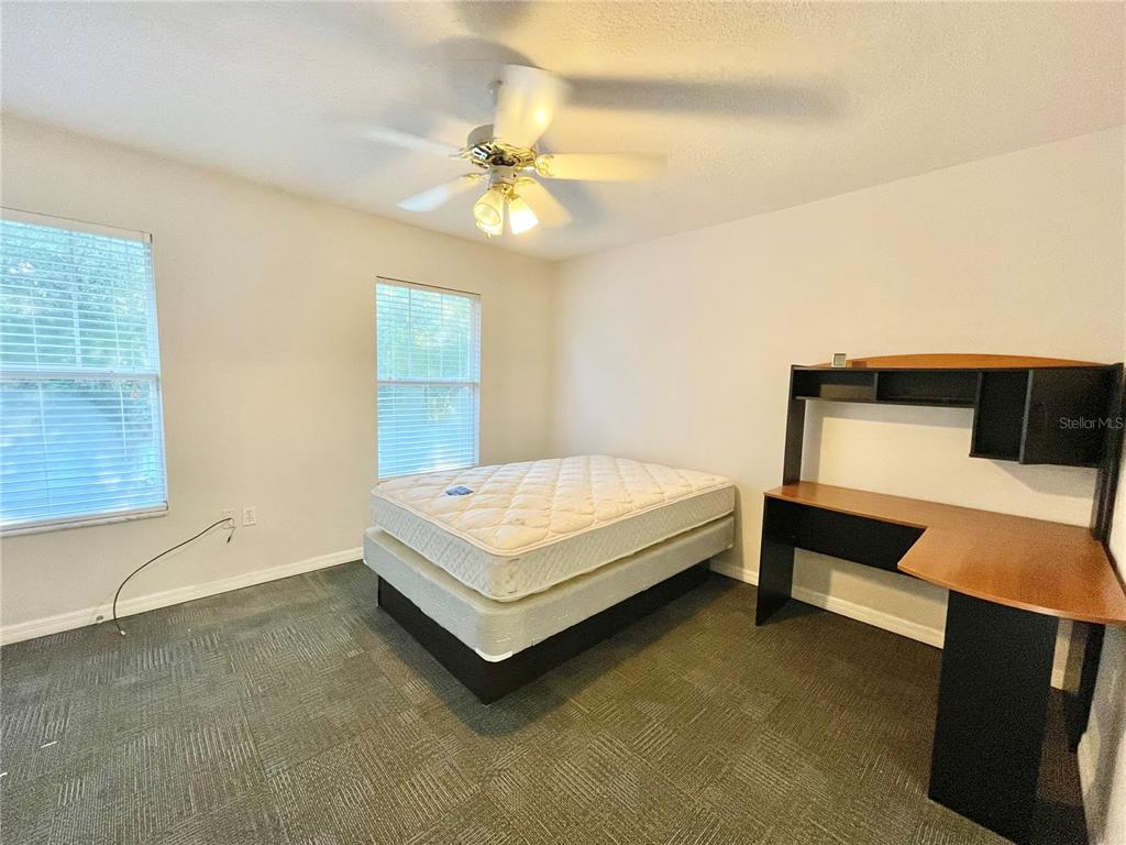2348 Southwest 42nd Drive, Unit 151 Gainesville, FL 32607 - Photo 18 of 28 a bedroom with a bed and a chandelier