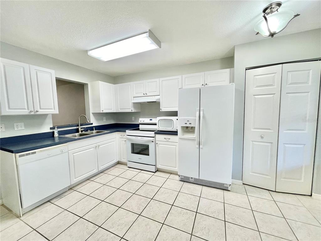 2348 Southwest 42nd Drive, Unit 151 Gainesville, FL 32607 - Photo 2 of 28 a kitchen with white cabinets a sink and white appliances