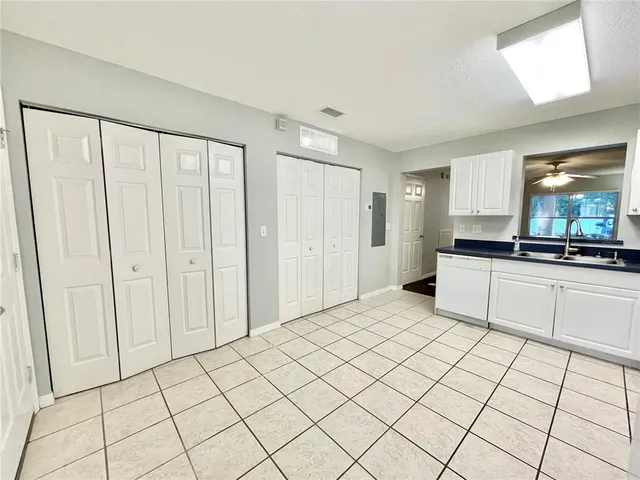 a large white kitchen with a sink and cabinets