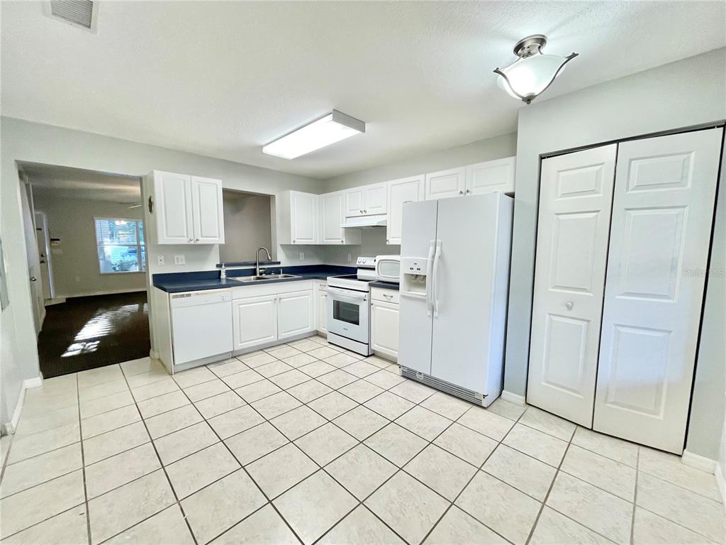 2348 Southwest 42nd Drive, Unit 151 Gainesville, FL 32607 - Photo 7 of 28 a kitchen with a cabinets a sink a window and stainless steel appliances