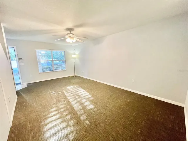 en empty room with windows and ceiling fan view