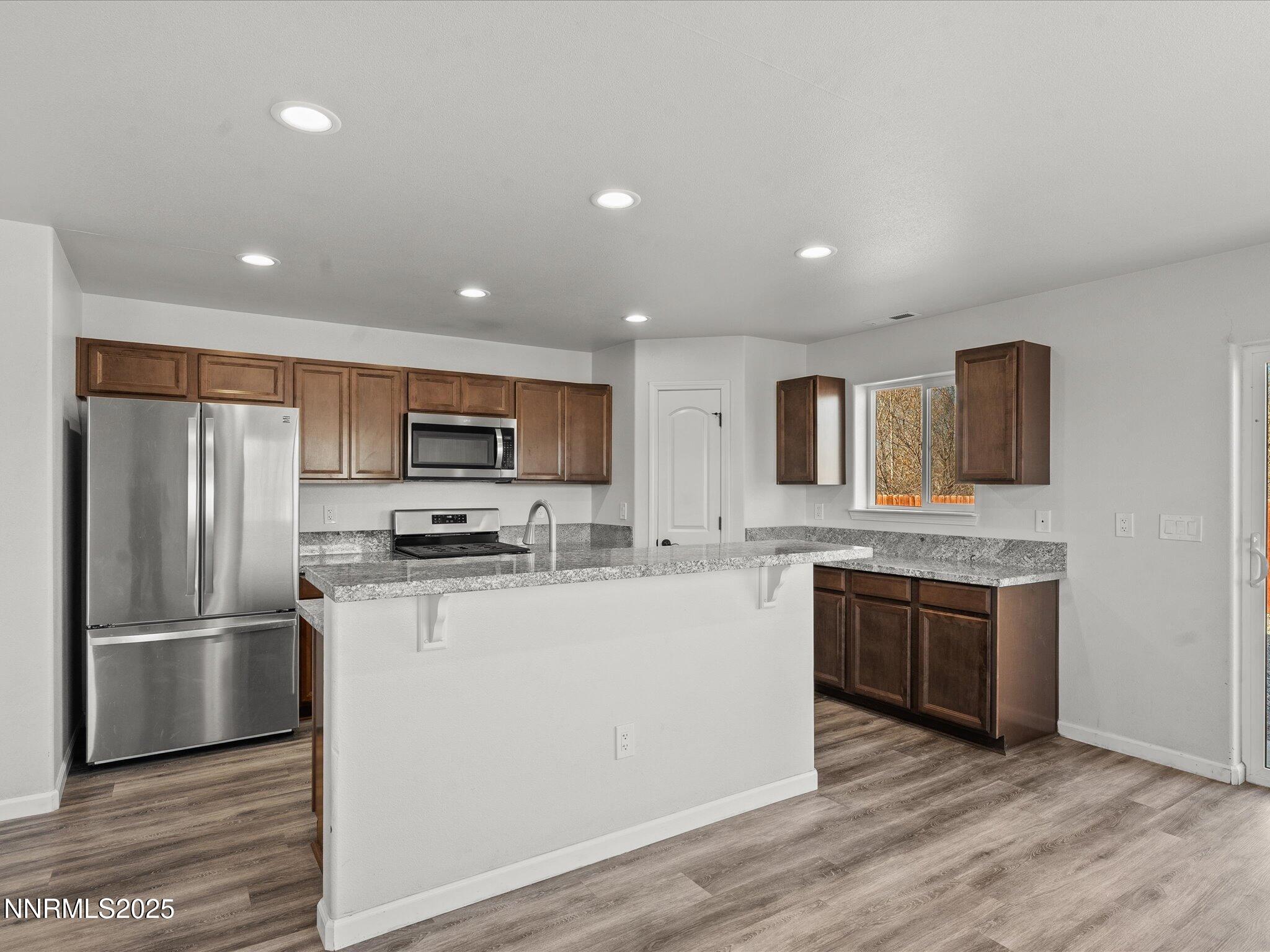 2041 Verona Drive Fallon, NV 89406 - Photo 11 of 45 a kitchen with stainless steel appliances granite countertop a refrigerator a stove top oven a sink and dishwasher with wooden floor
