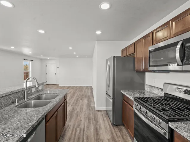 a kitchen with stainless steel appliances granite countertop a sink stove and refrigerator
