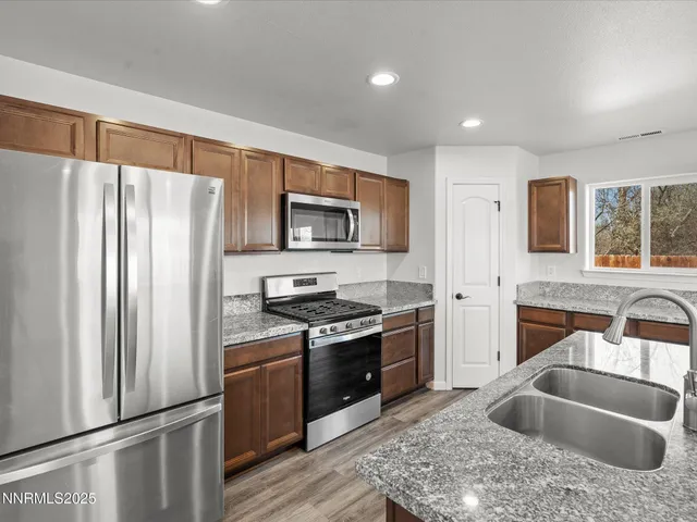 a kitchen with stainless steel appliances granite countertop a refrigerator stove and sink