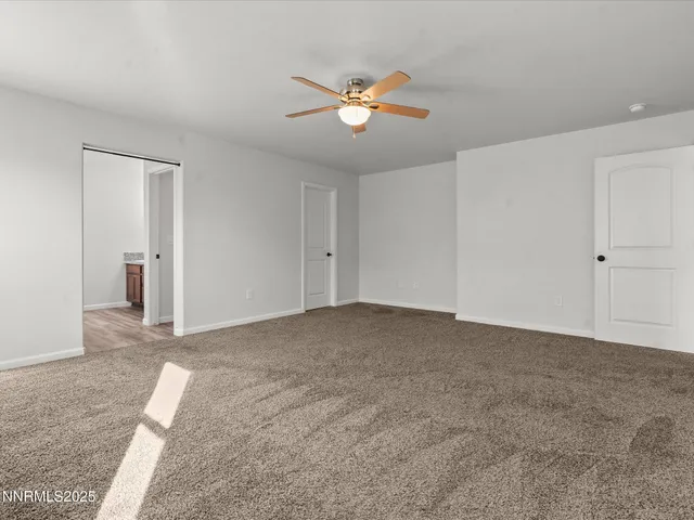 a view of a livingroom with a ceiling fan and window