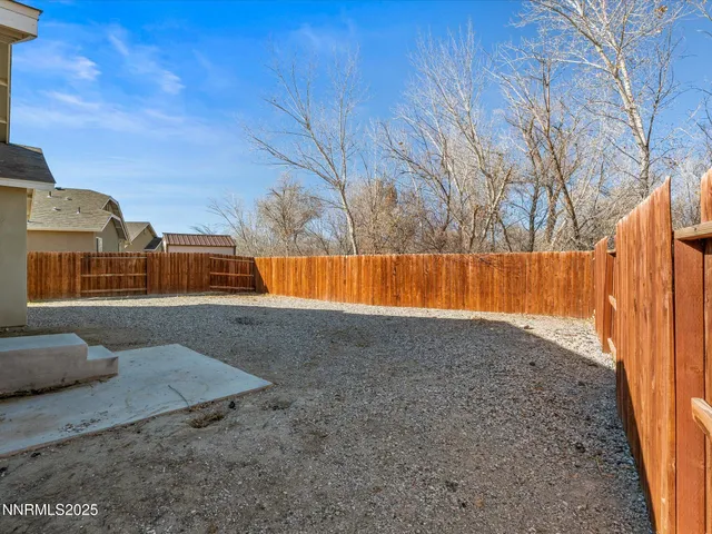 a view of backyard with wooden fence