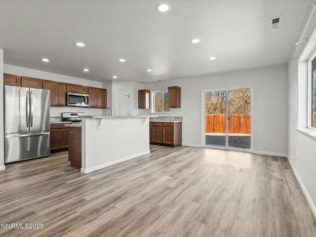 a view of kitchen with wooden floor electronic appliances and window