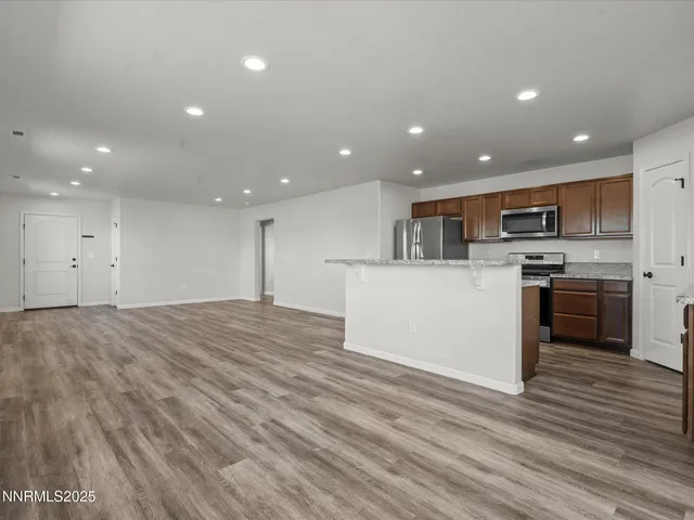 a view of kitchen view wooden cabinets and stainless steel appliances