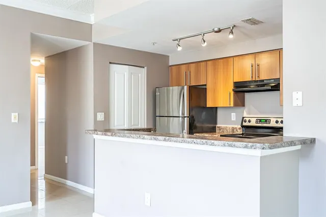 a kitchen with stainless steel appliances granite countertop a sink and a refrigerator
