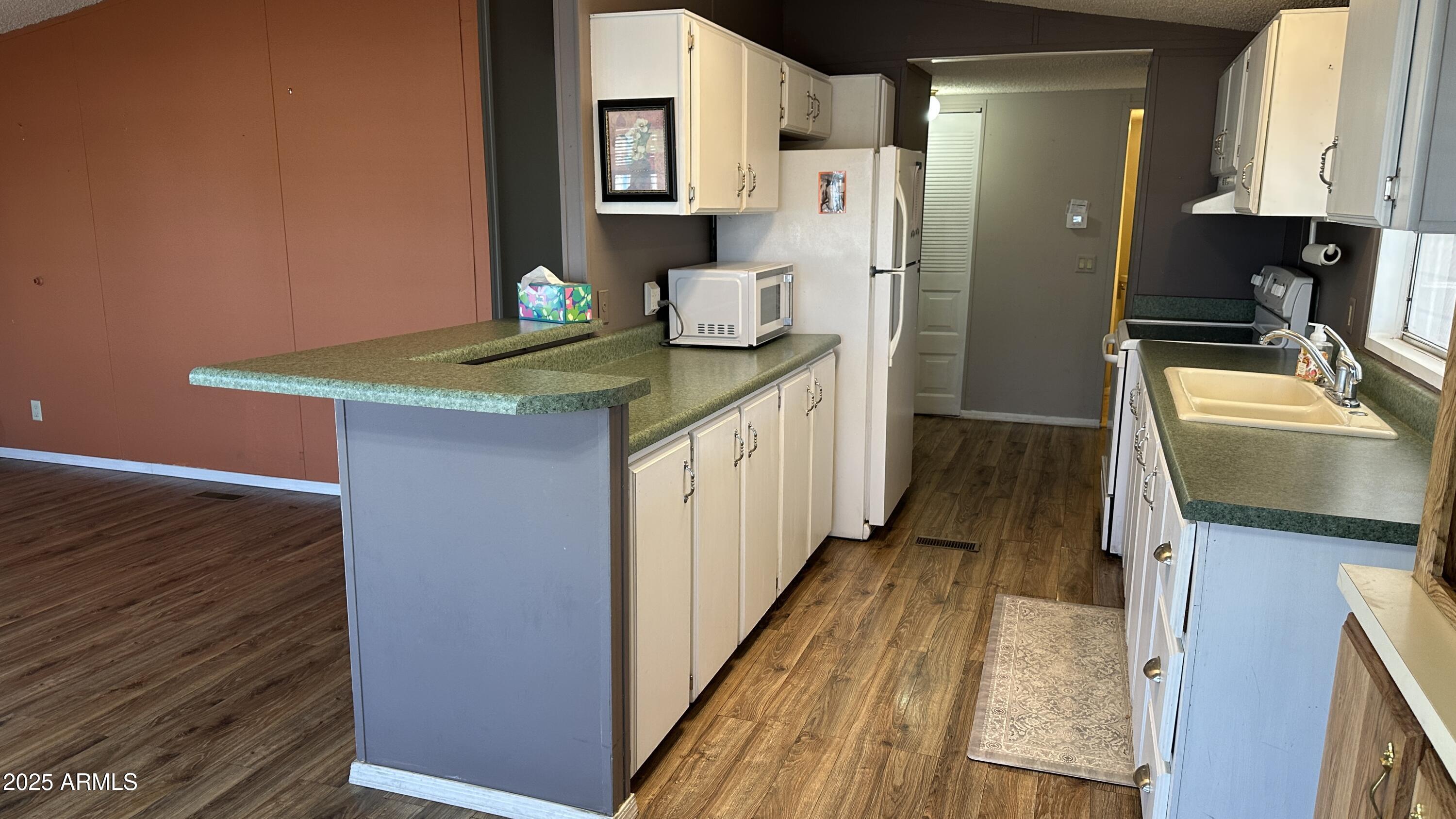 834 South Meridian Road, Unit 105 Apache Junction, AZ 85120 - Photo 7 of 48 a kitchen with granite countertop a sink stove and refrigerator