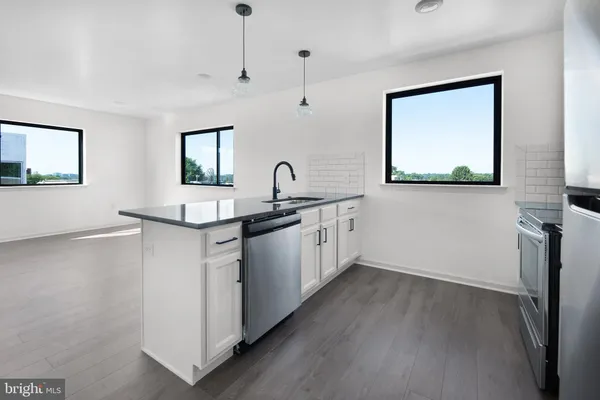 a kitchen with stainless steel appliances granite countertop a sink stove and wooden floor