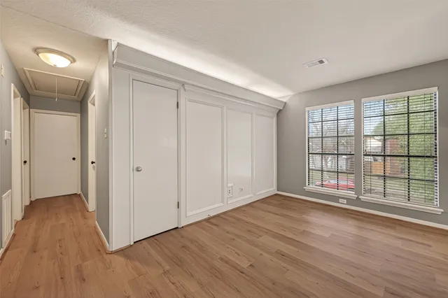 a view of an empty room with glass door and wooden floor